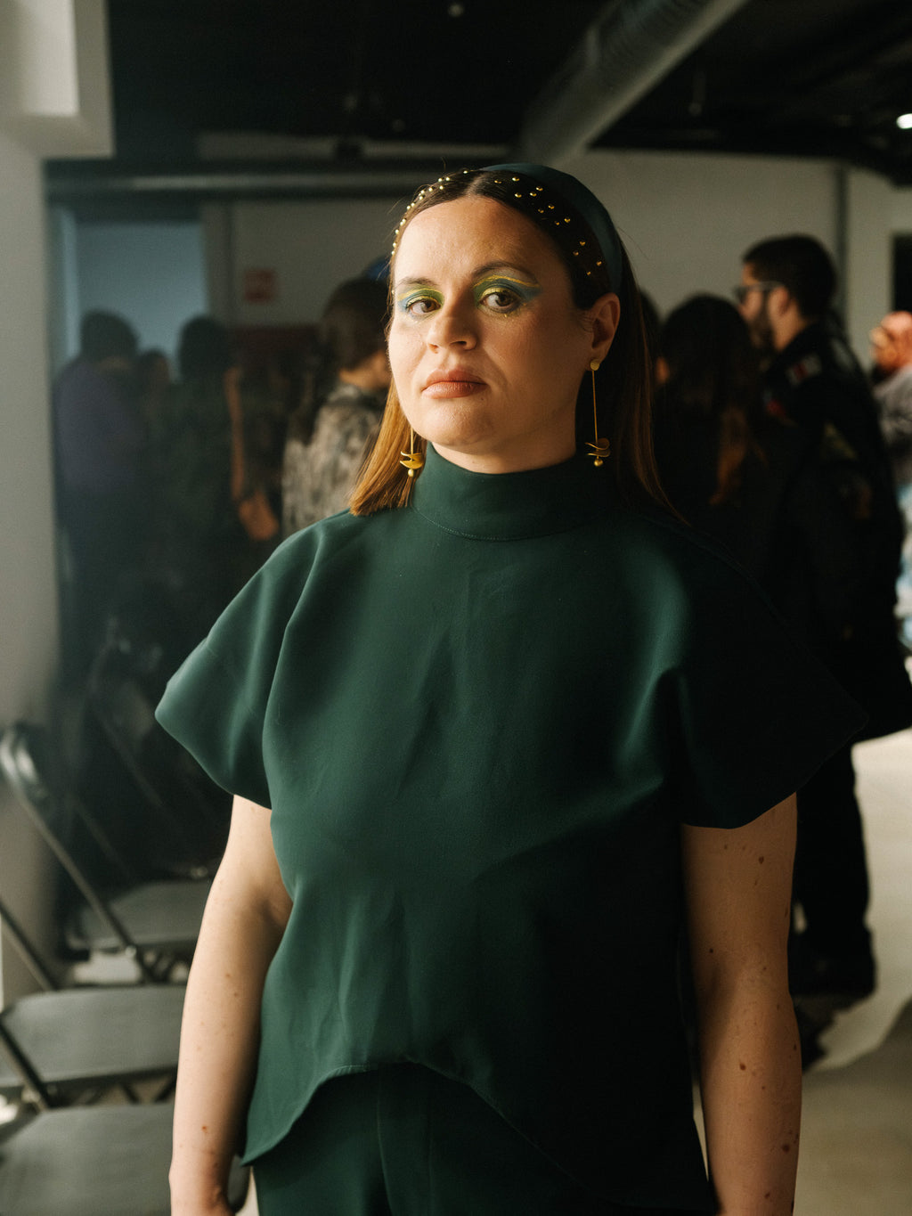 The Diva Top in forest green featuring an architectural high neck and sculptural sleeves.