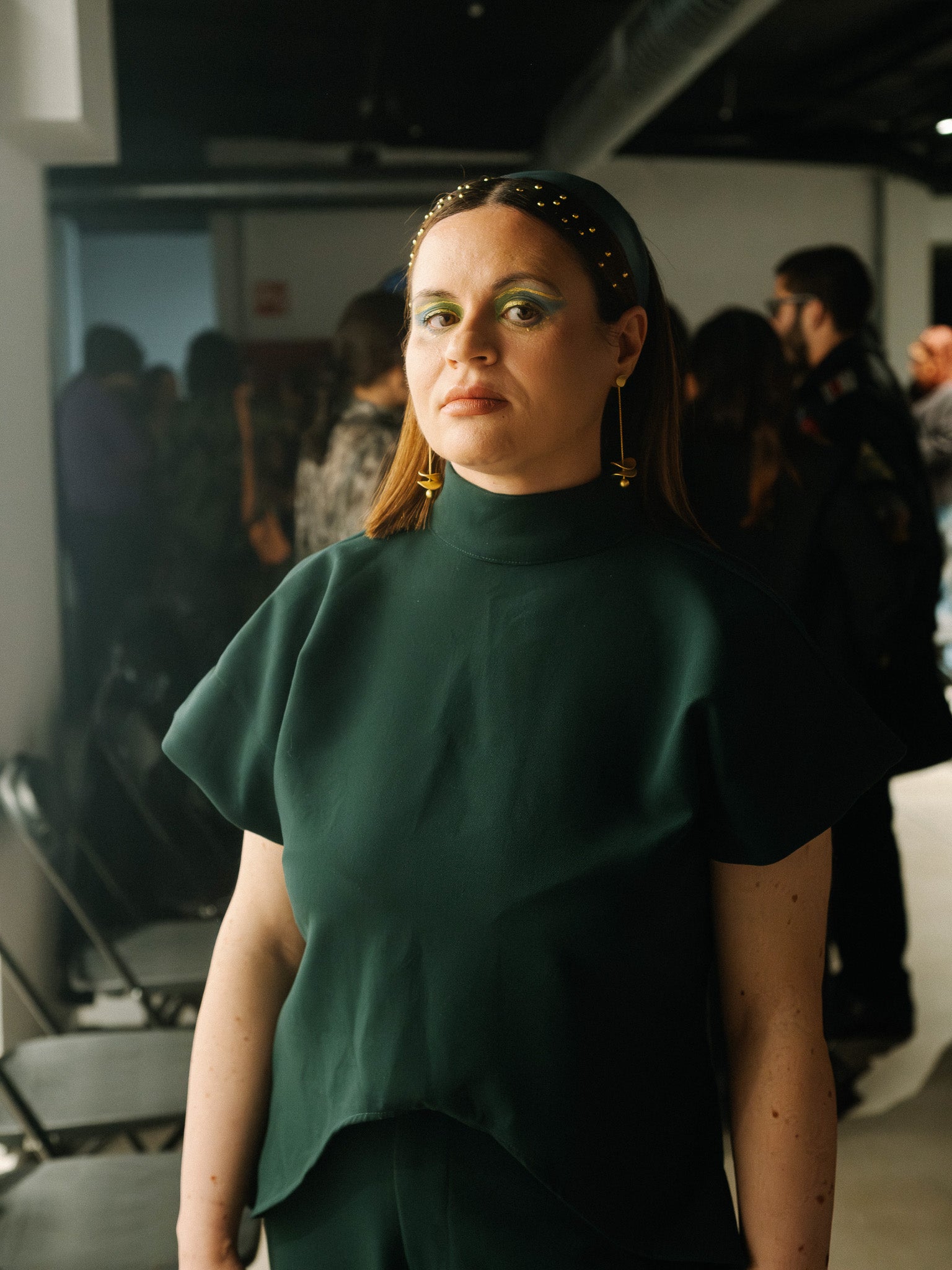The Diva Top in forest green featuring an architectural high neck and sculptural sleeves.