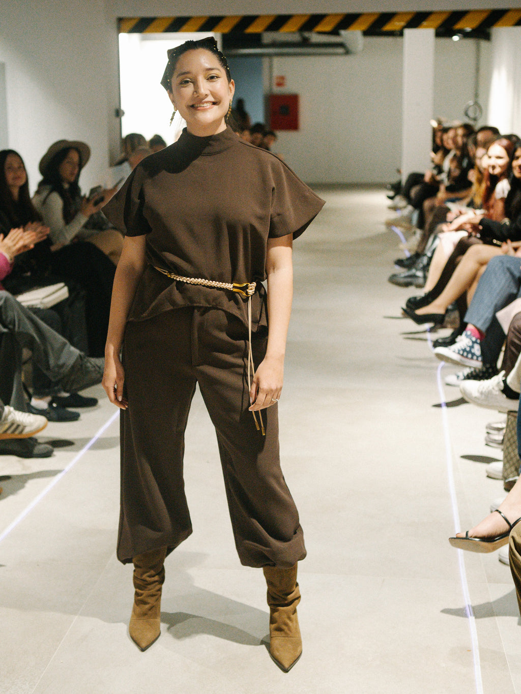 Diva Top and Bossy Pants in Coffee brown modeled on the runway showing the fluid wide-leg movement.