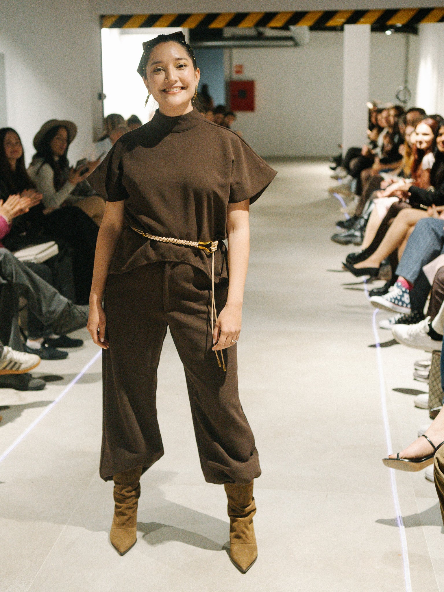 Diva Top and Bossy Pants in Coffee brown modeled on the runway showing the fluid wide-leg movement.