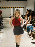 Halfen House Model walking on a fashion show runway with an audience watching wearing the luna top and the maracana skort.