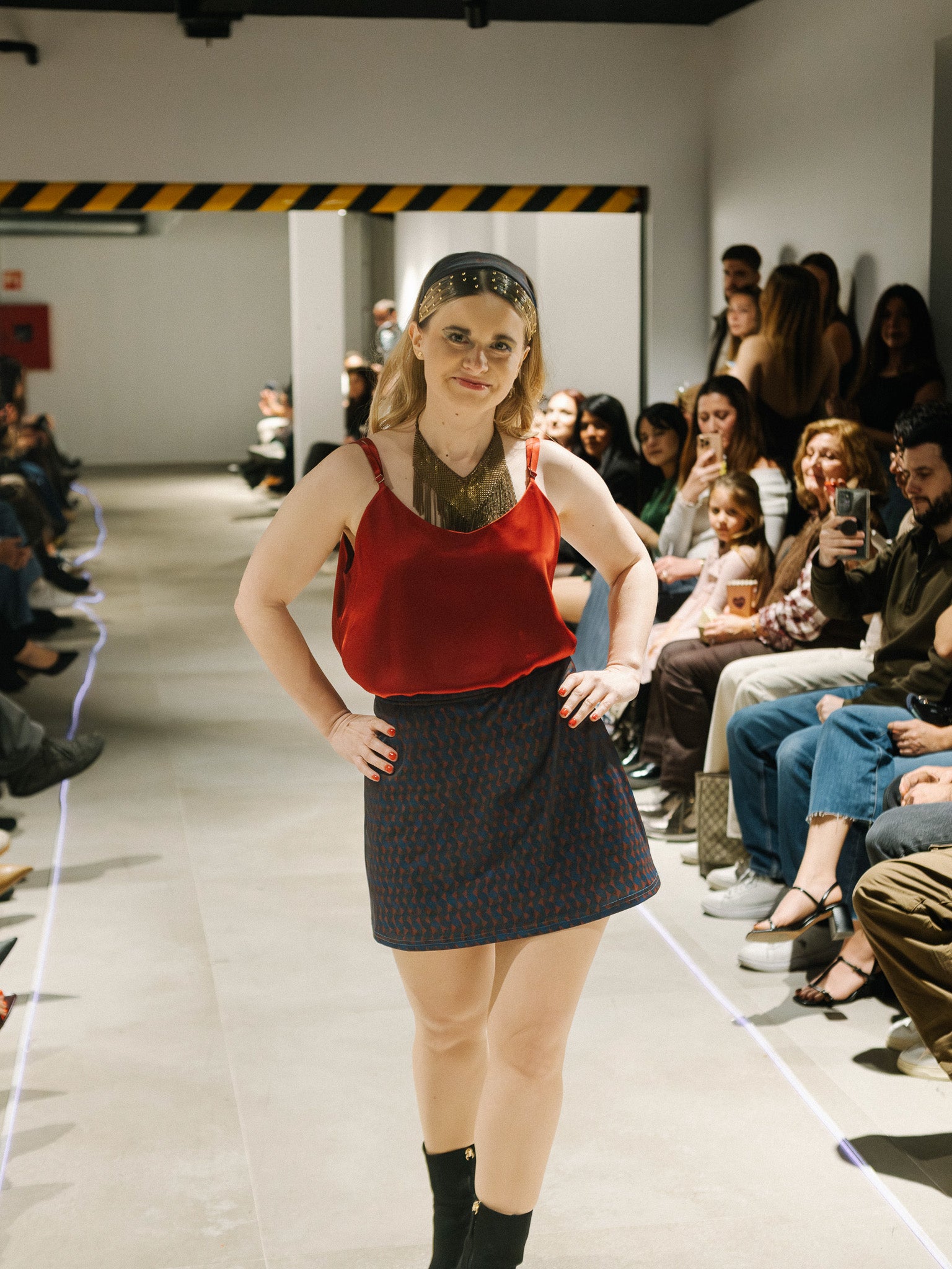Halfen House Model walking on a fashion show runway with an audience watching wearing the luna top and the maracana skort.