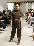 Model wearing The Diva and Bossy outfit on a fashion show runway with an audience.